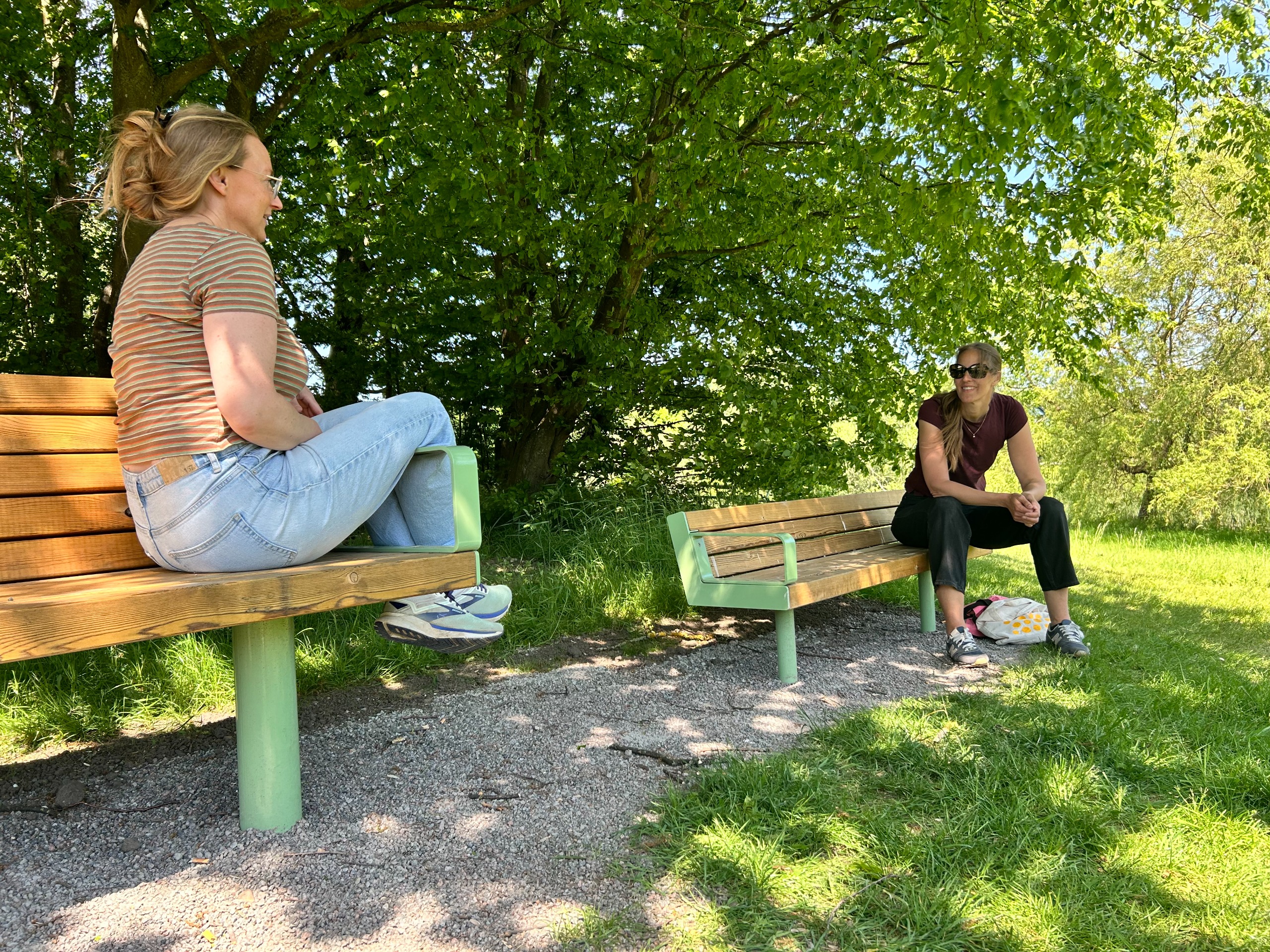 Två personer på två bänkar varav den ena är mindre