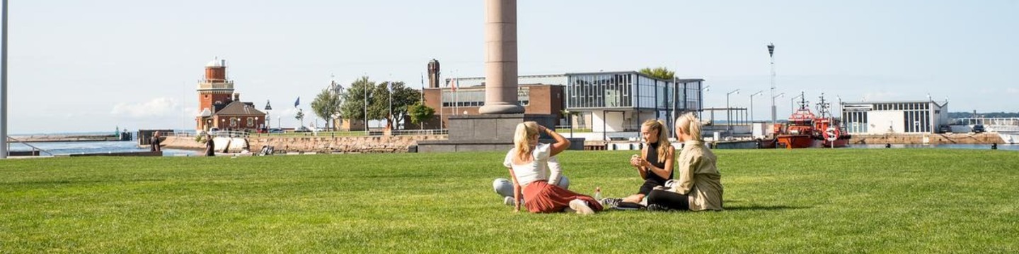 Människor sitter i en park och pratar med varandra