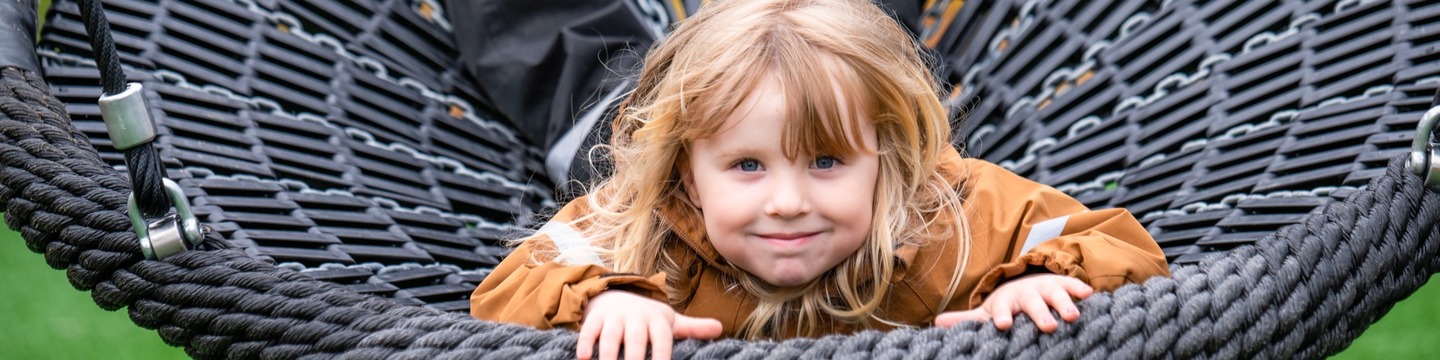 Ett barn i en stor rund gunga