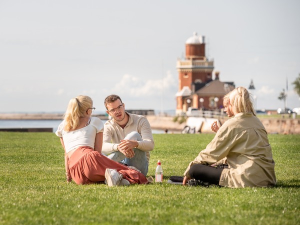 Människor sitter i en park och pratar med varandra