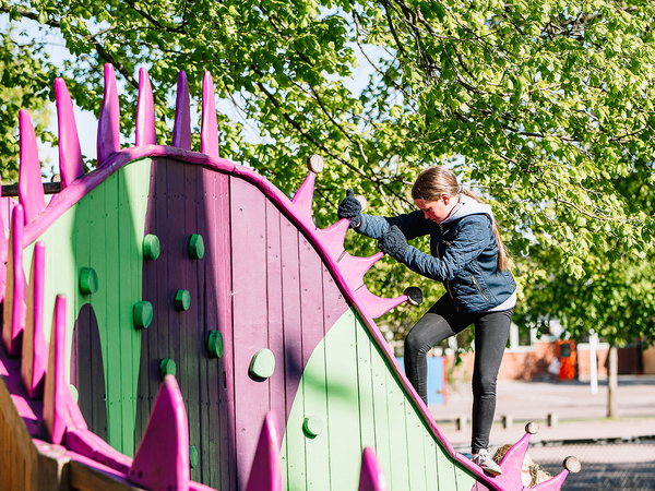 Flicka klättrar på lekplats